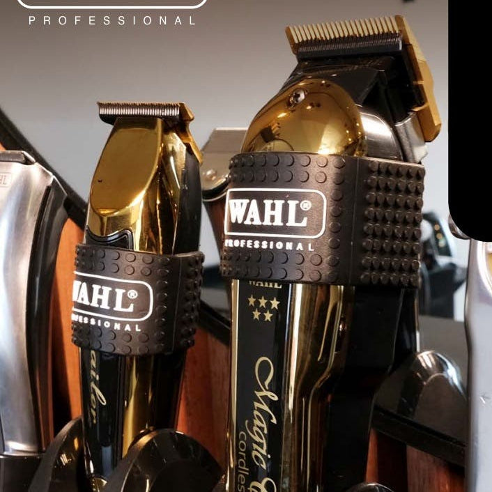 Gold Wahl professional hair trimmer in a holder with visible branding with clipper grips